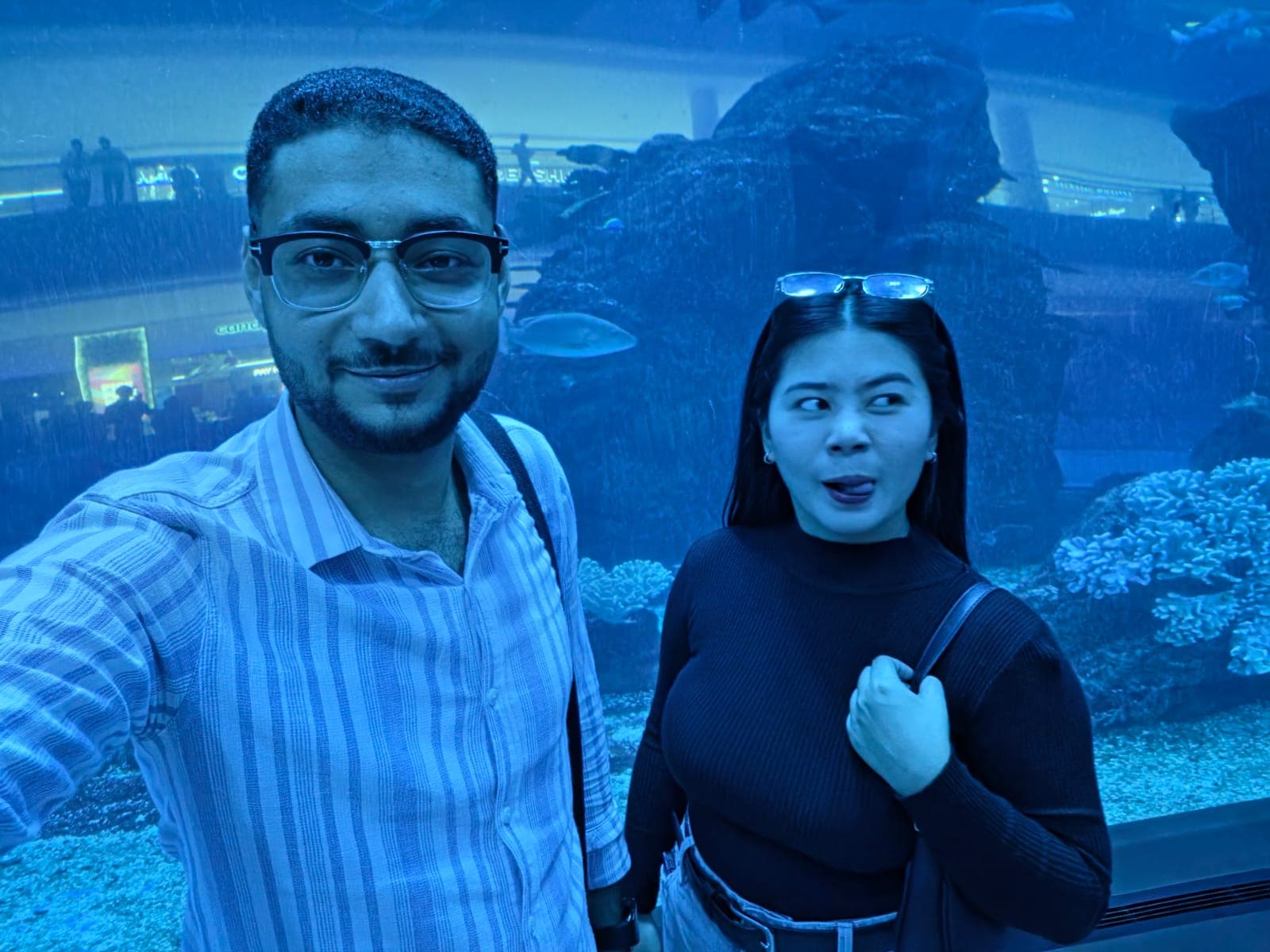 Kim sticking her tongue out and side-eyeing me in our aquarium selfie